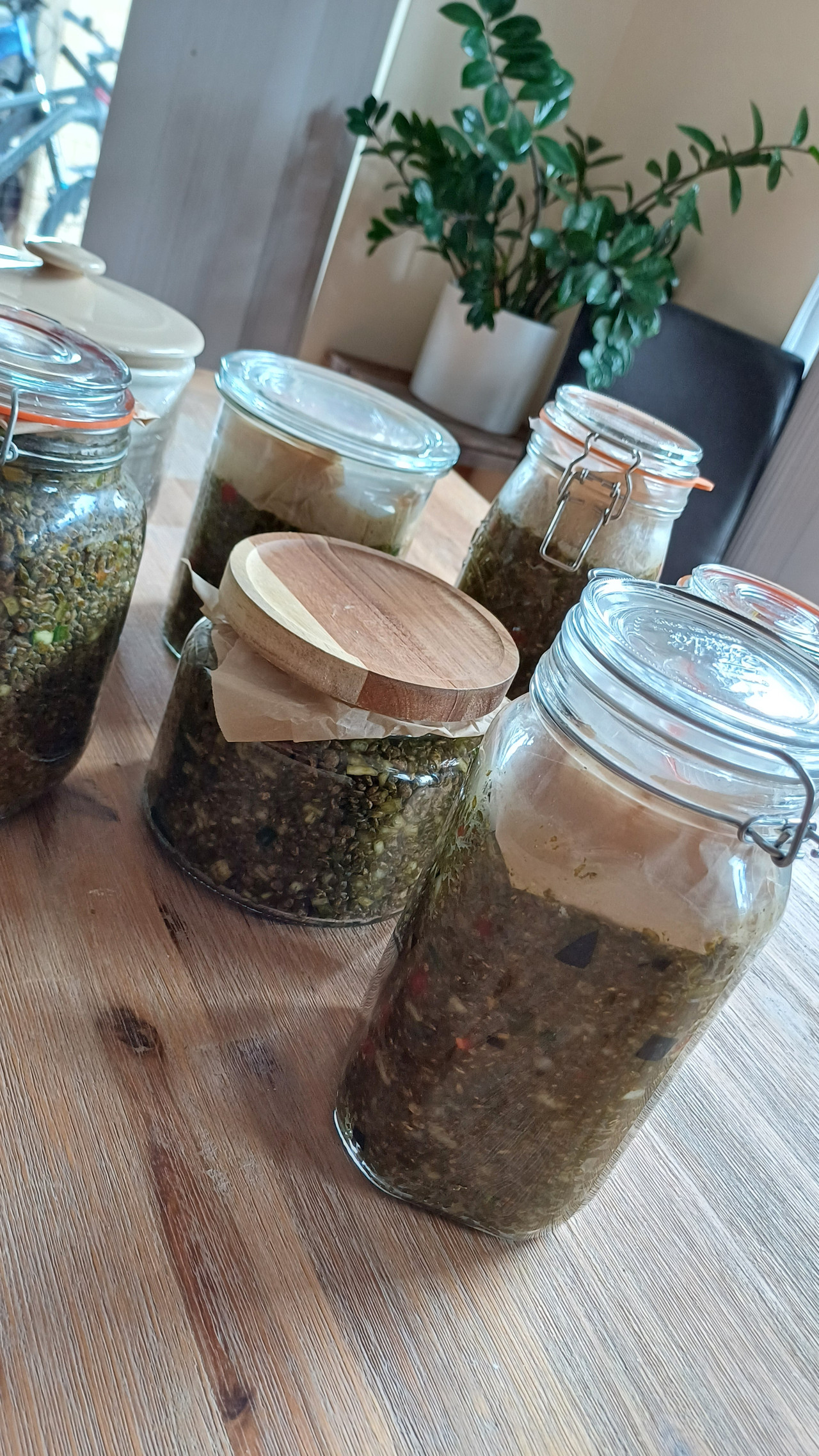 Hands hand-glazing a ceramic jar of seasoning